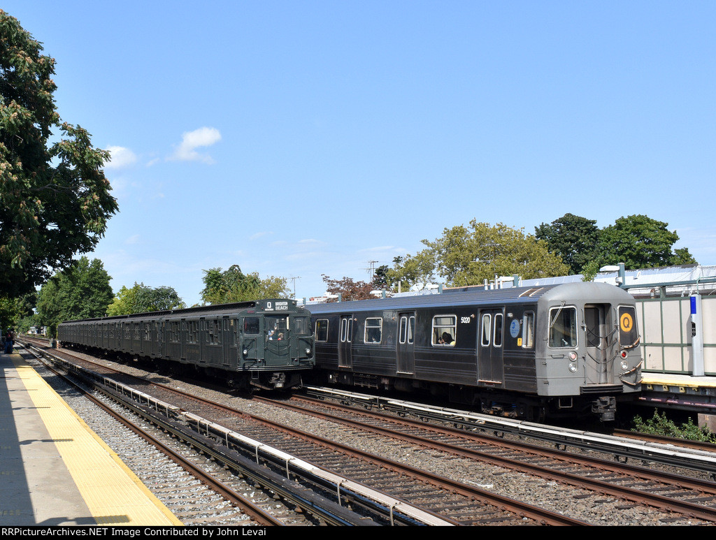 Northbound Arnines and a Q train of R-68A cars heading away from Neck Rd Station